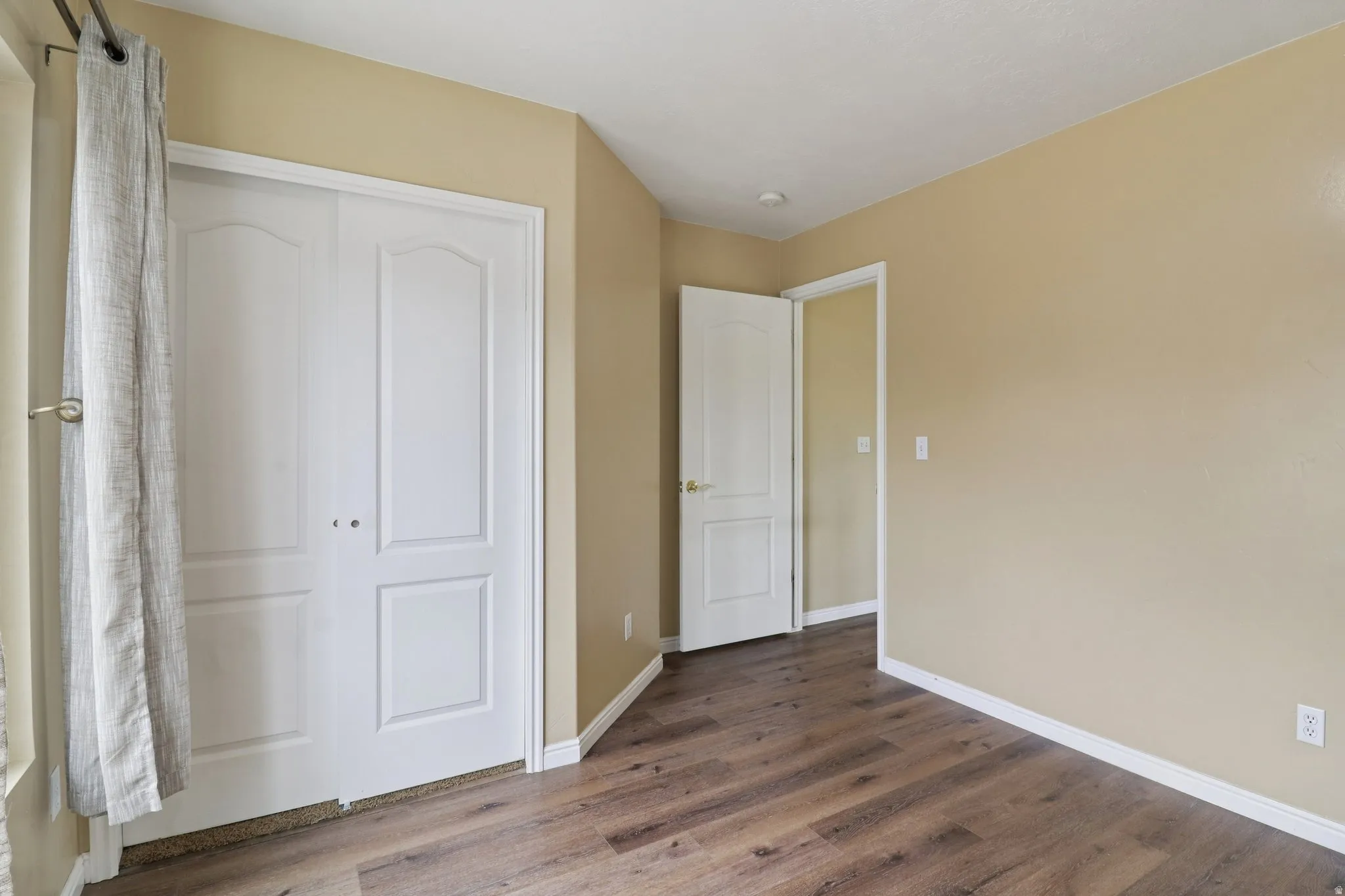 Unfurnished bedroom with dark wood finished floors and a closet