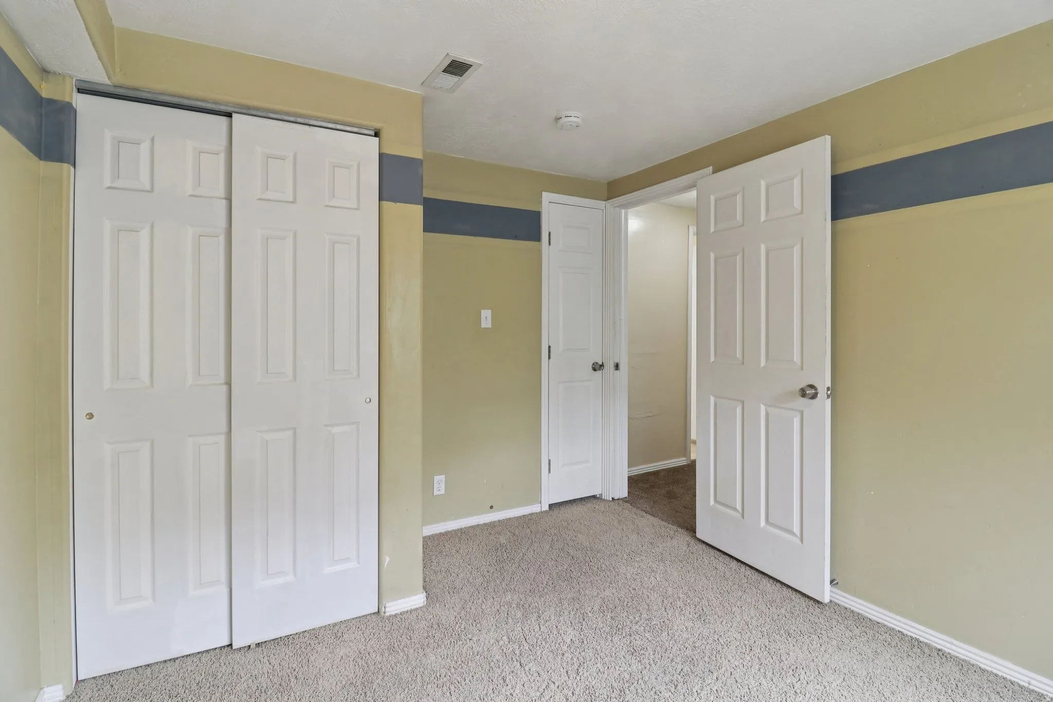 Unfurnished bedroom with light carpet and a closet