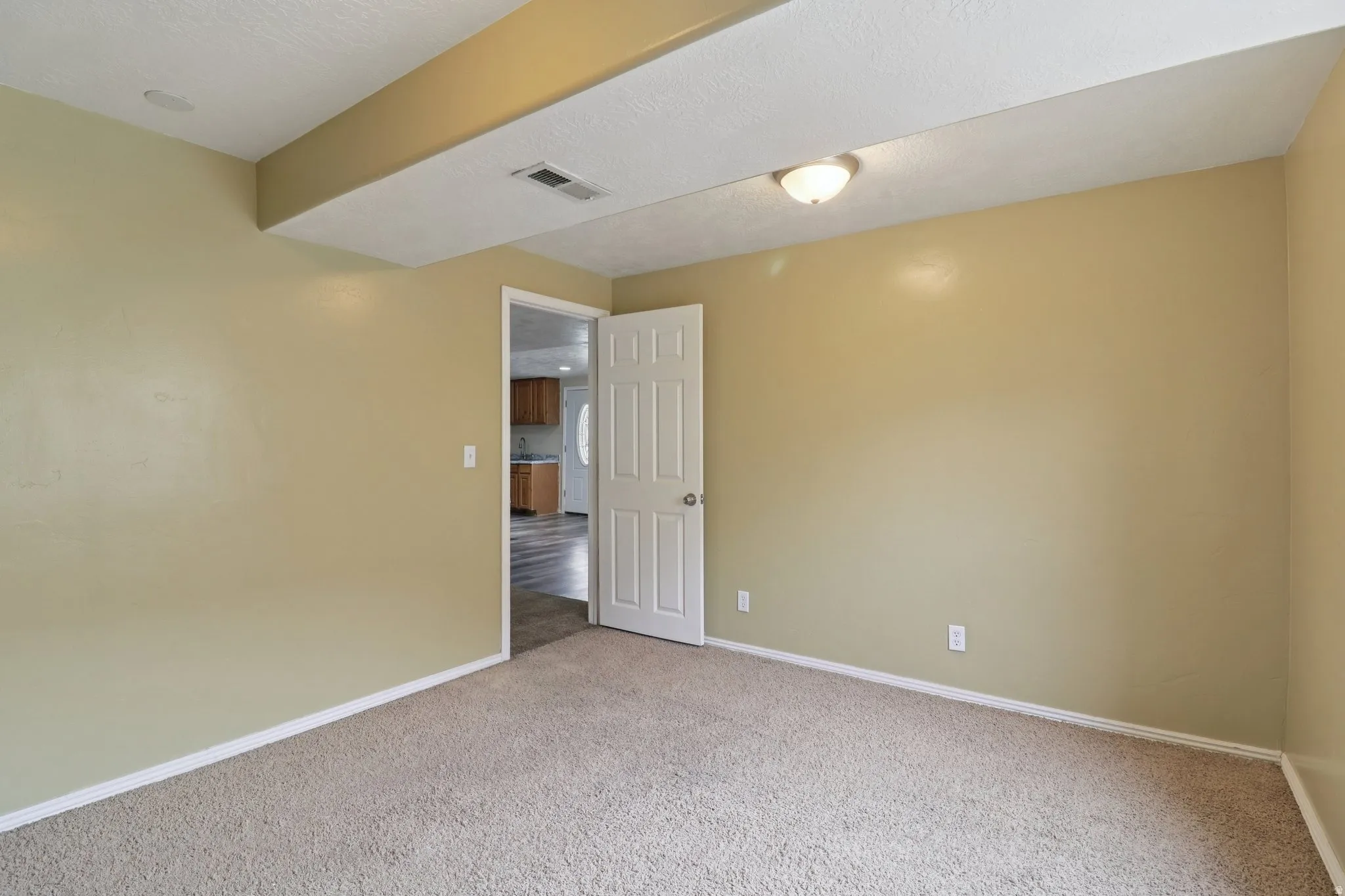 Spare room featuring light carpet and a textured ceiling