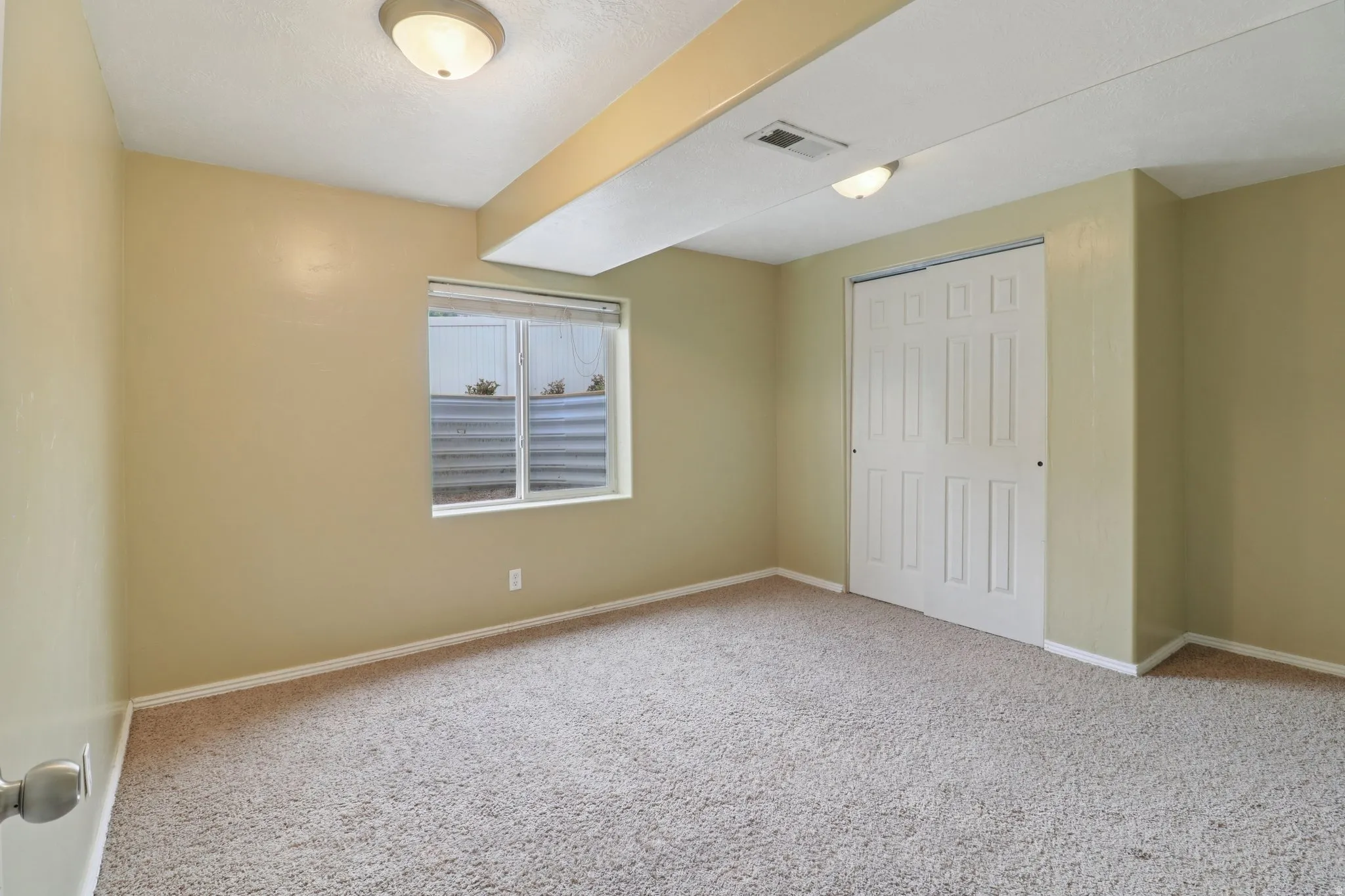 Unfurnished bedroom featuring a closet and light colored carpet