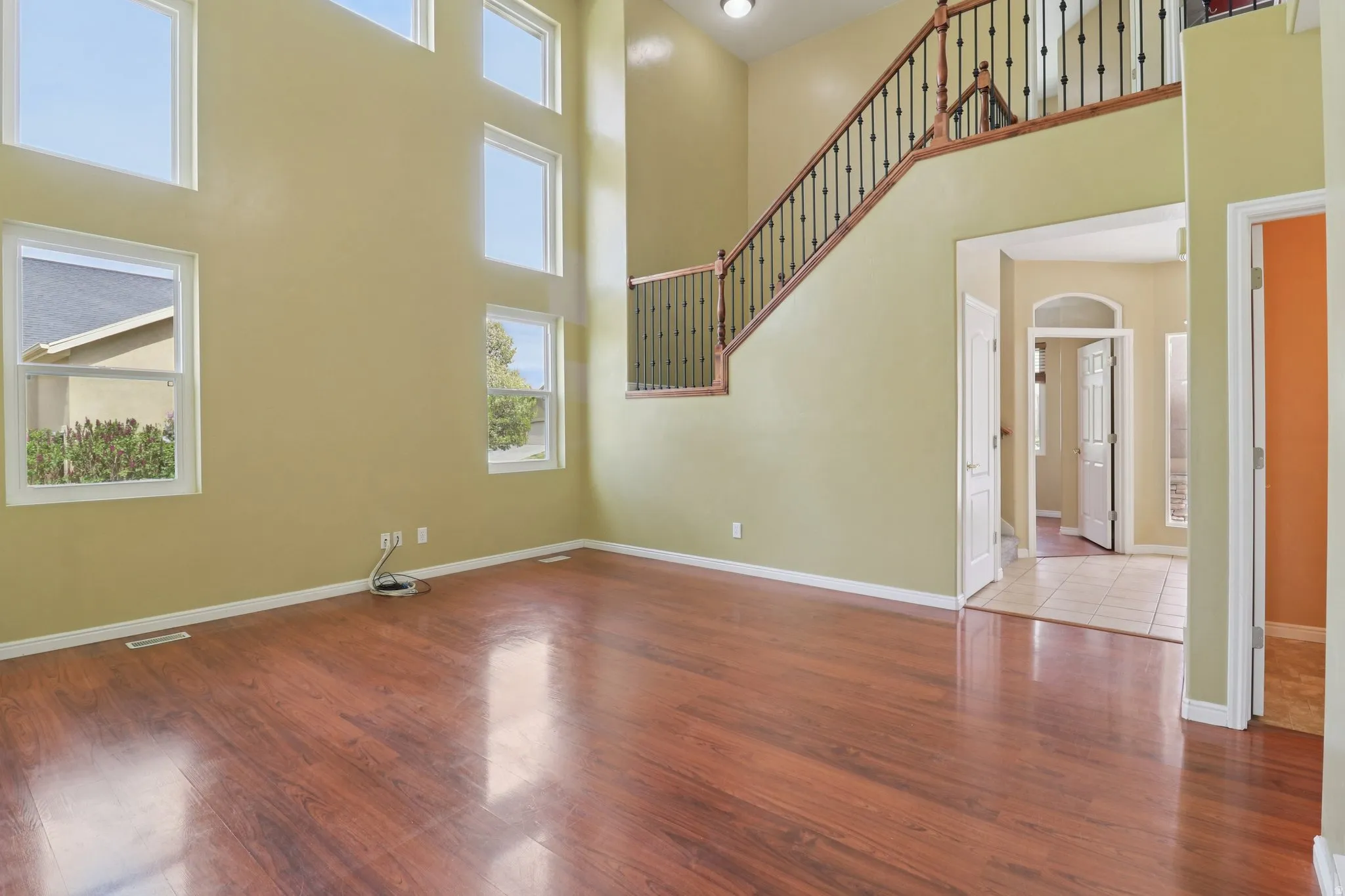 Unfurnished living room with a high ceiling and wood finished floors
