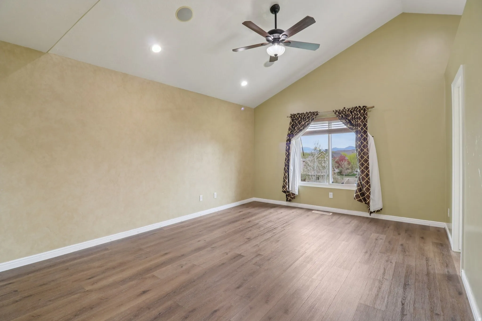 Unfurnished room featuring lofted ceiling, dark wood-style floors, ceiling fan, and recessed lighting
