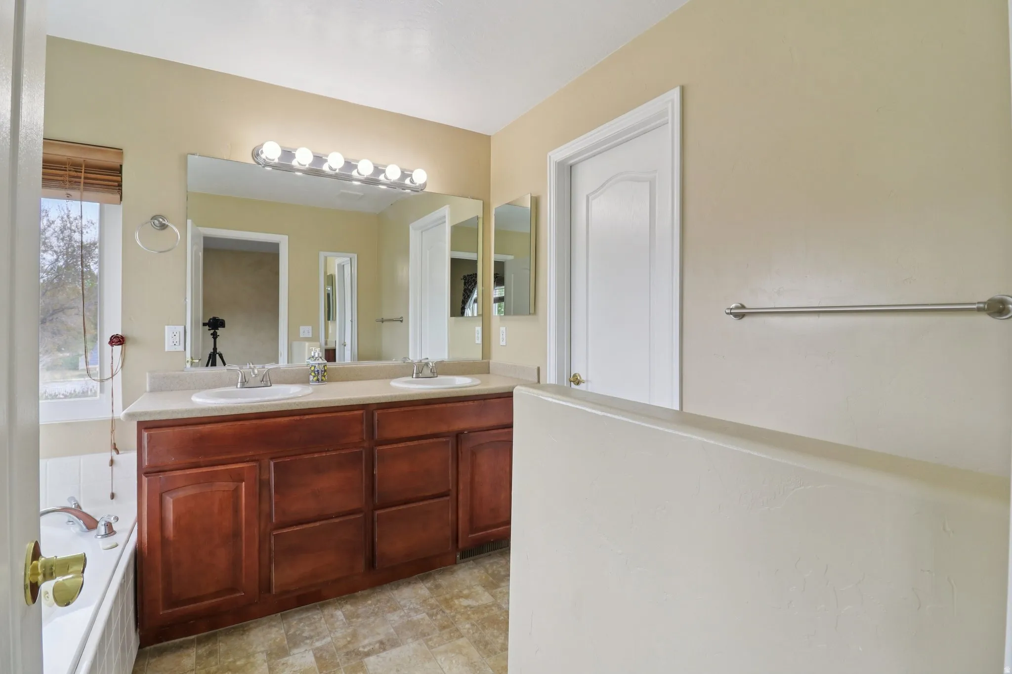 Bathroom featuring double vanity and a garden tub