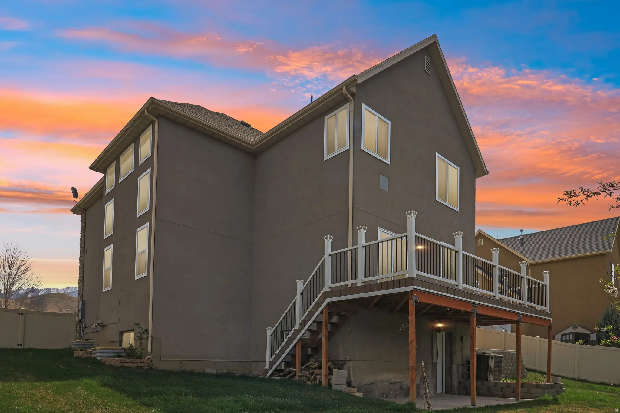 Back of property with stucco siding, a patio area, and a deck