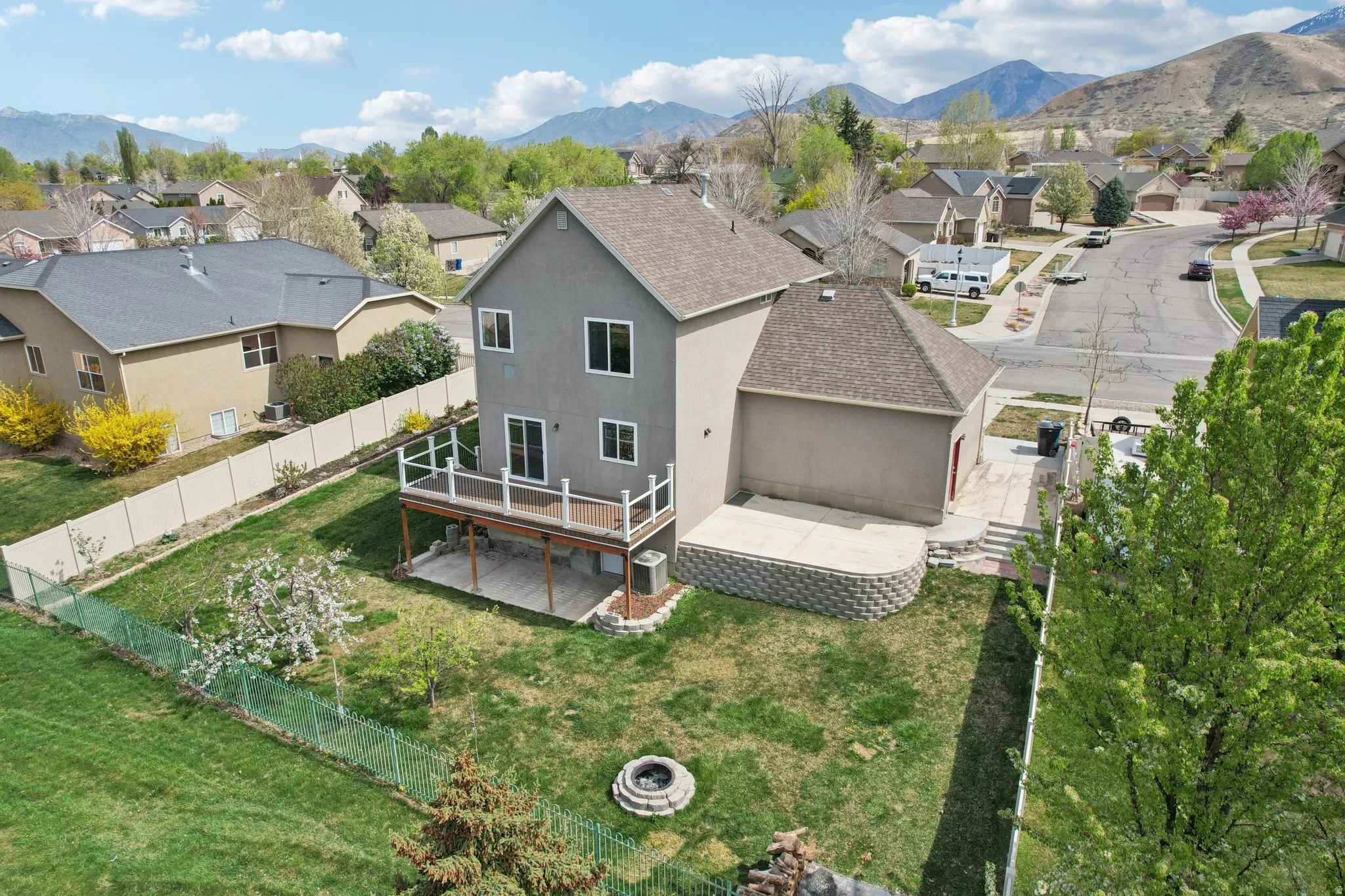 Rear view of house with roof with shingles, a fenced backyard, a deck with mountain view, a residential view, and stucco siding