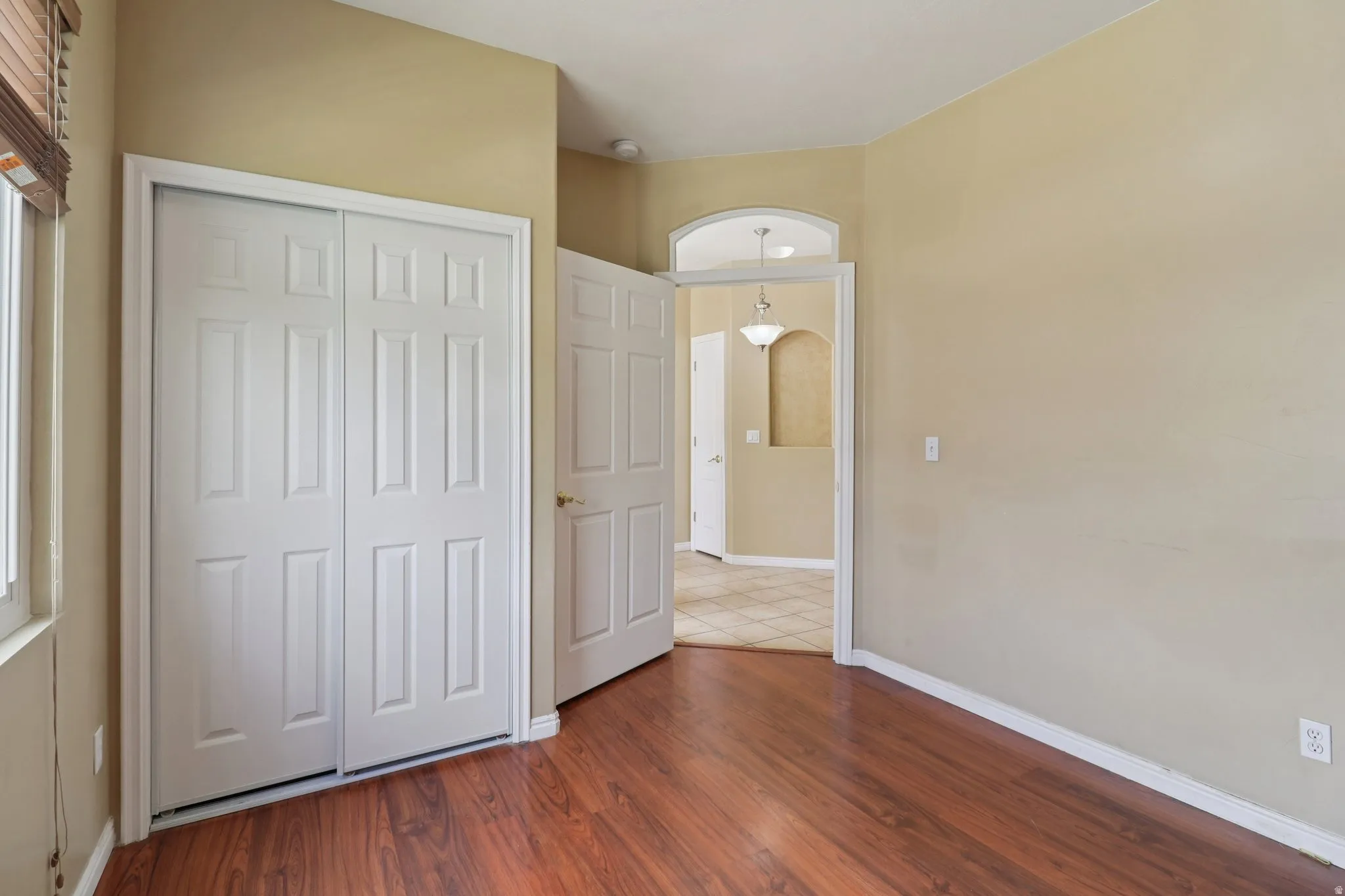 Unfurnished bedroom featuring dark wood-style flooring and a closet