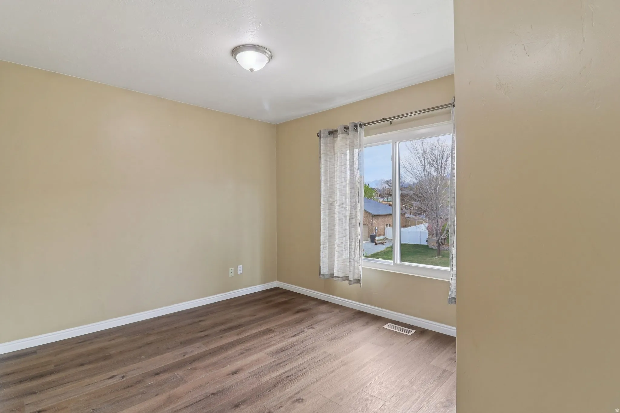 Spare room with dark wood-type flooring and baseboards