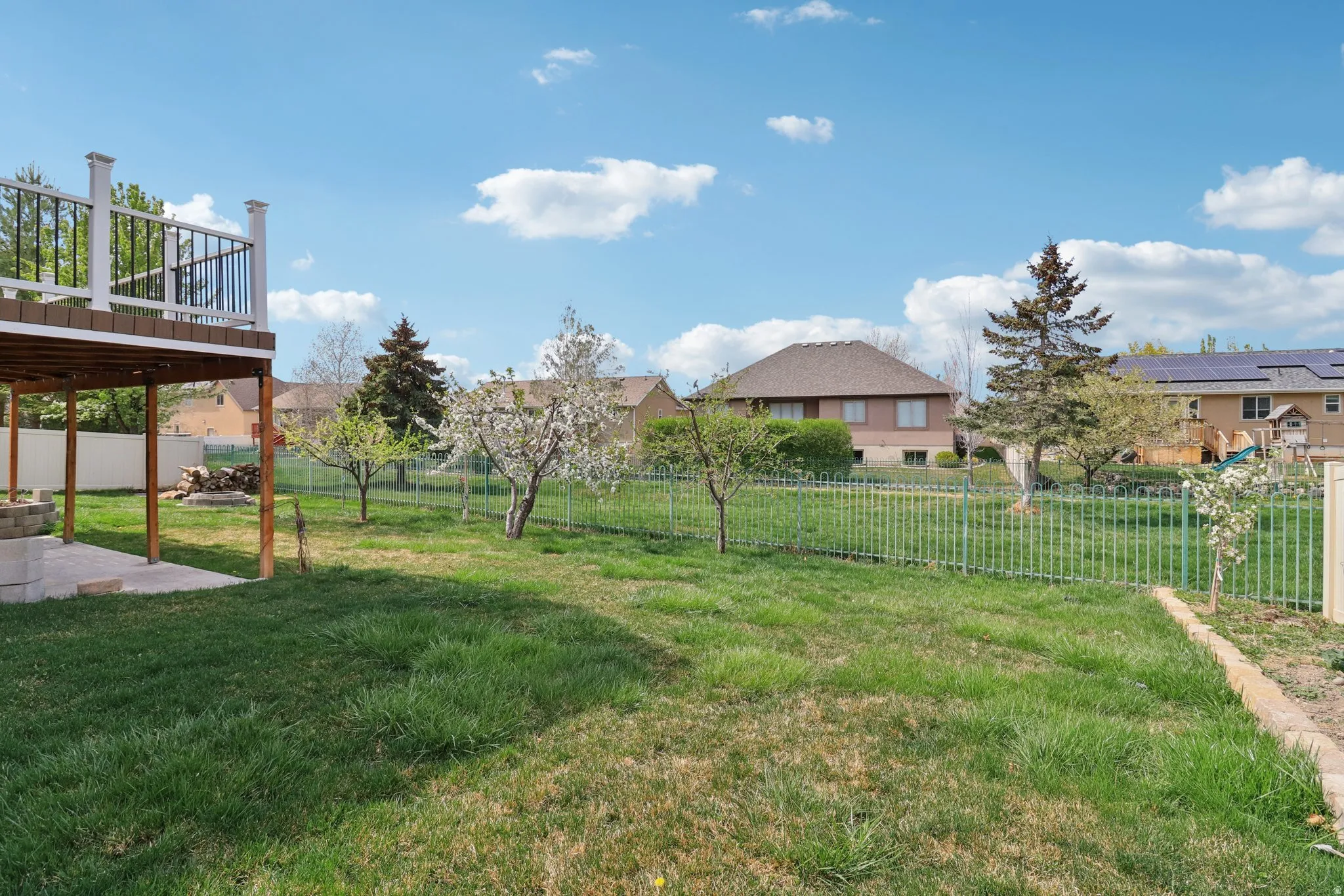 Fenced backyard featuring a residential view, a deck, and a patio