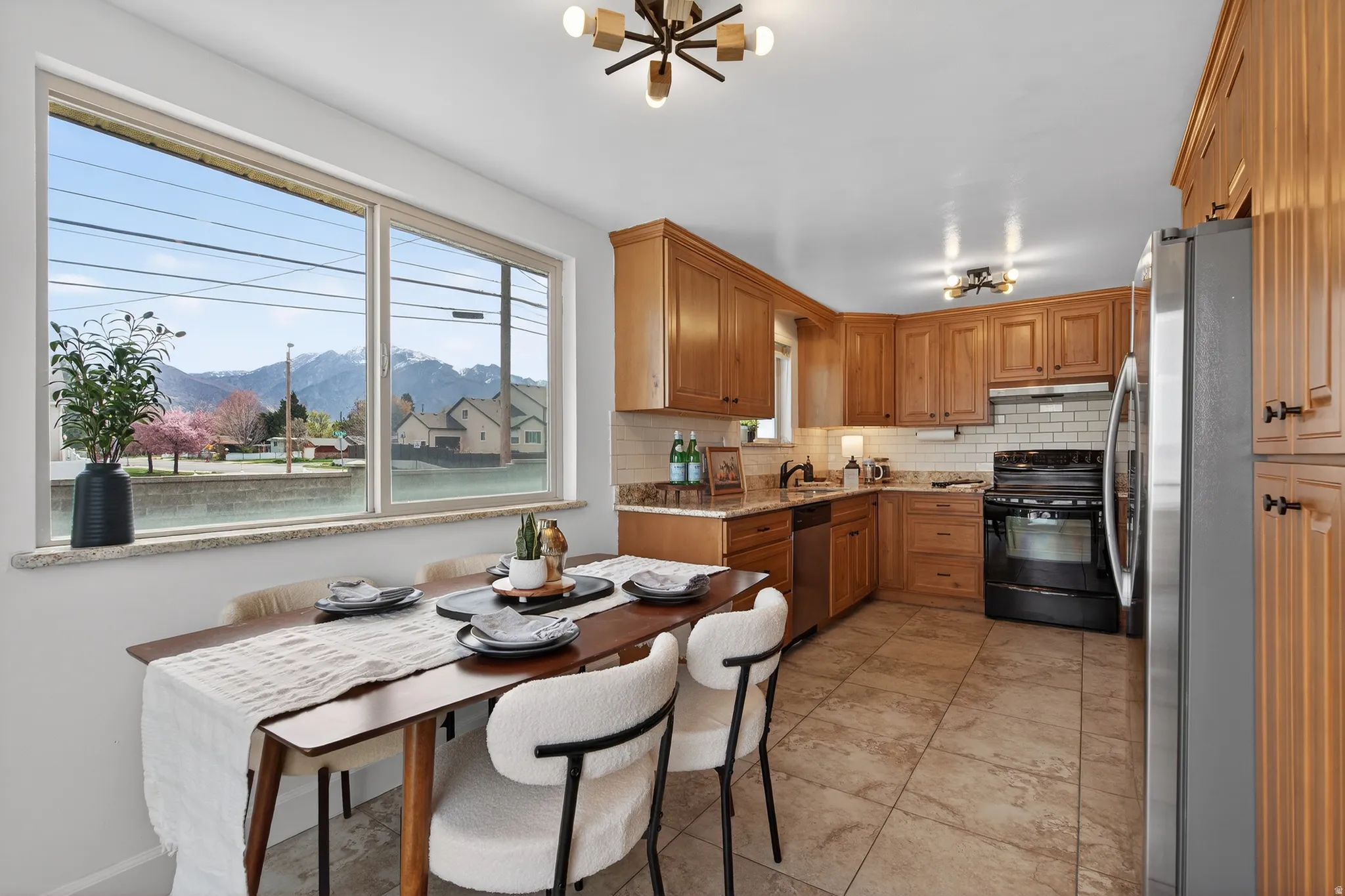 Kitchen with a mountain view, wood finish cabinets, stainless steel appliances, tile flooring and granite countertops