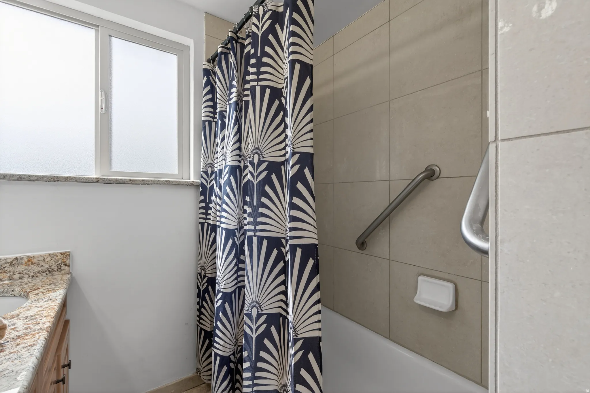 Full bathroom with double vanity and shower / tub combo