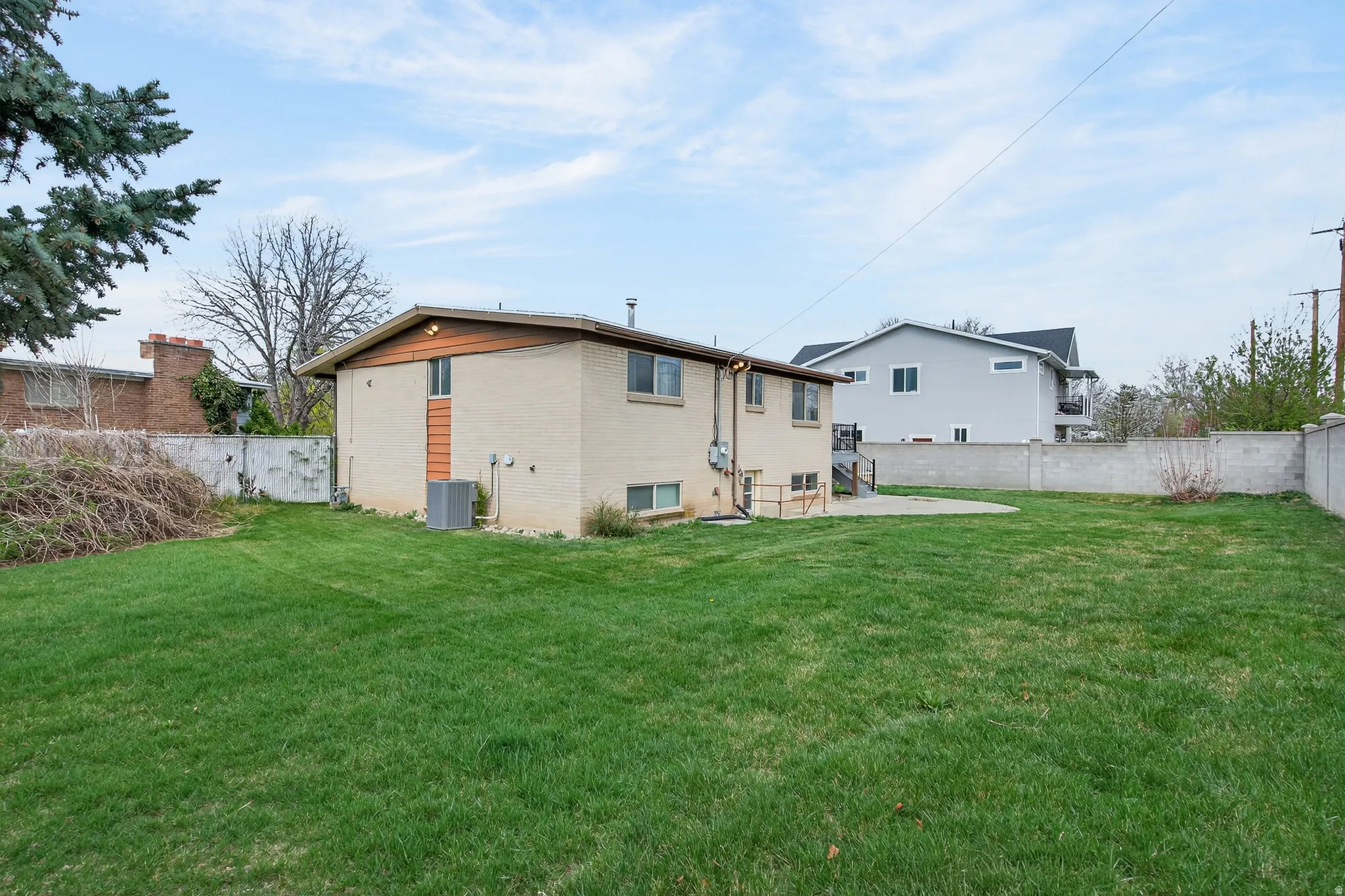 Back of property featuring a fully fenced backyard, brick siding, and a patio