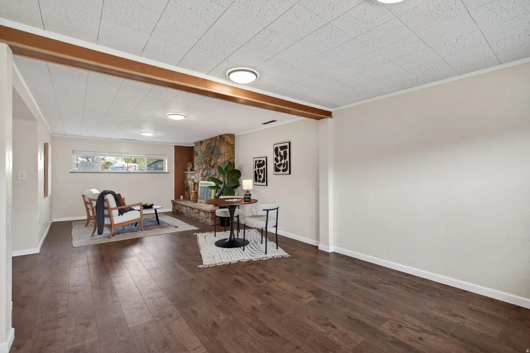 Living area featuring dark wood-type flooring and beam ceiling