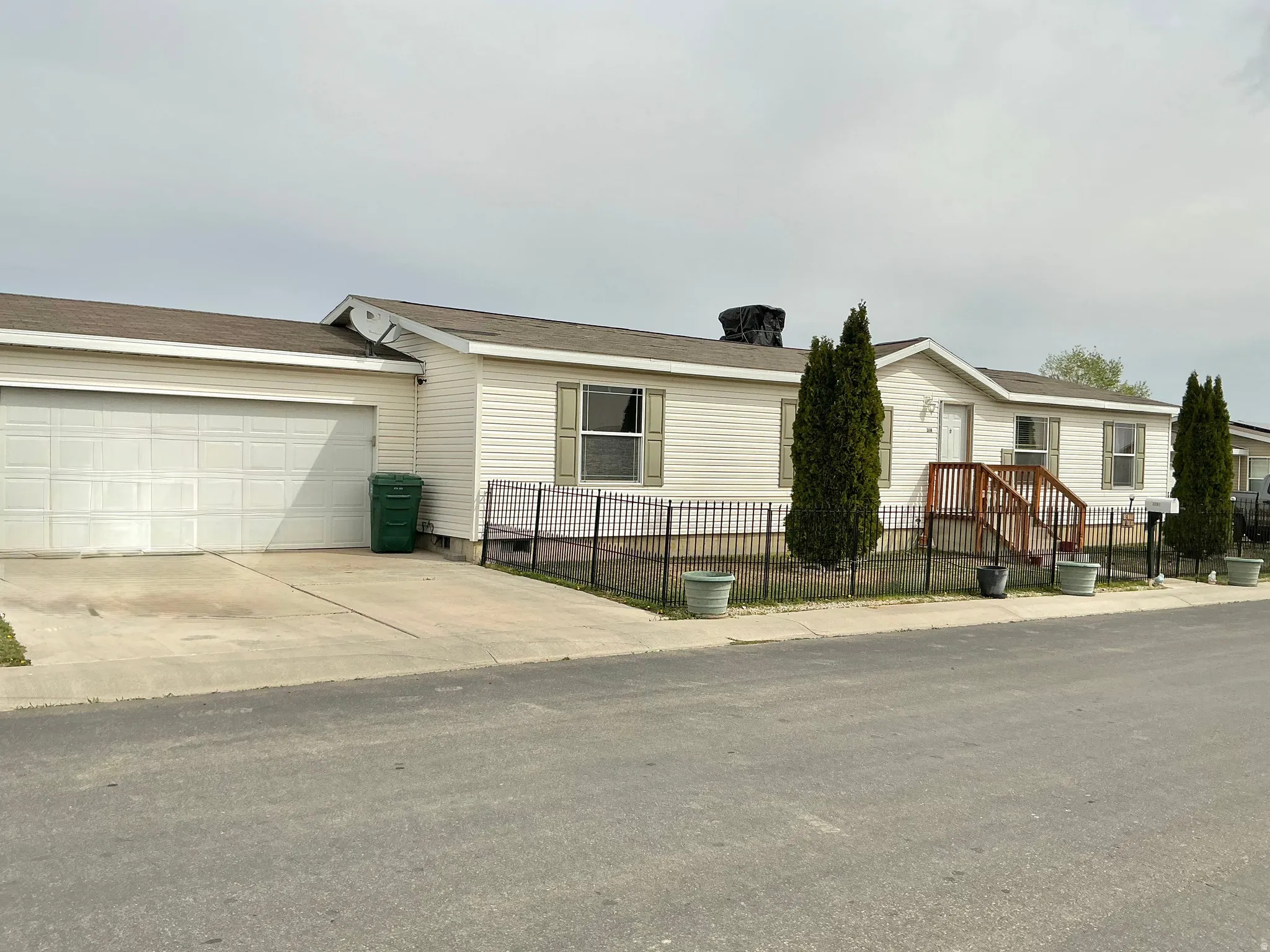 View of front of home with a fenced front yard, driveway, and a garage