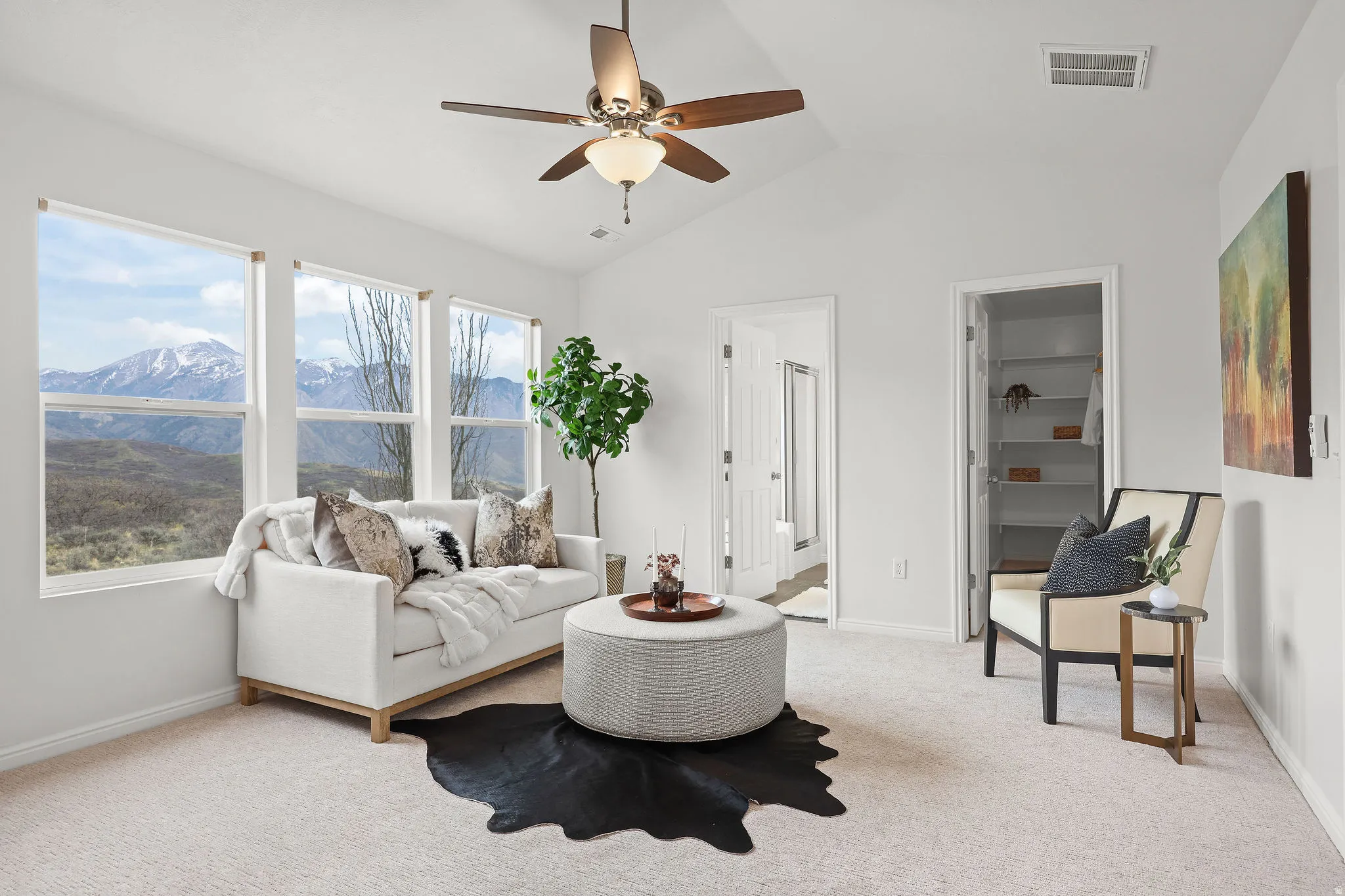 Living room with a ceiling fan, light carpet, a mountain view, and vaulted ceiling