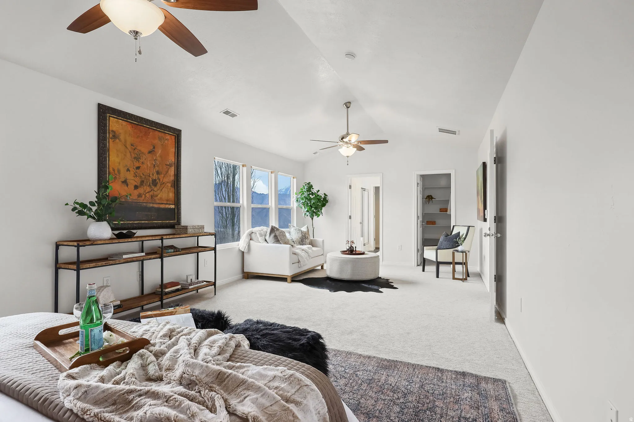 Carpeted living area featuring a ceiling fan and lofted ceiling
