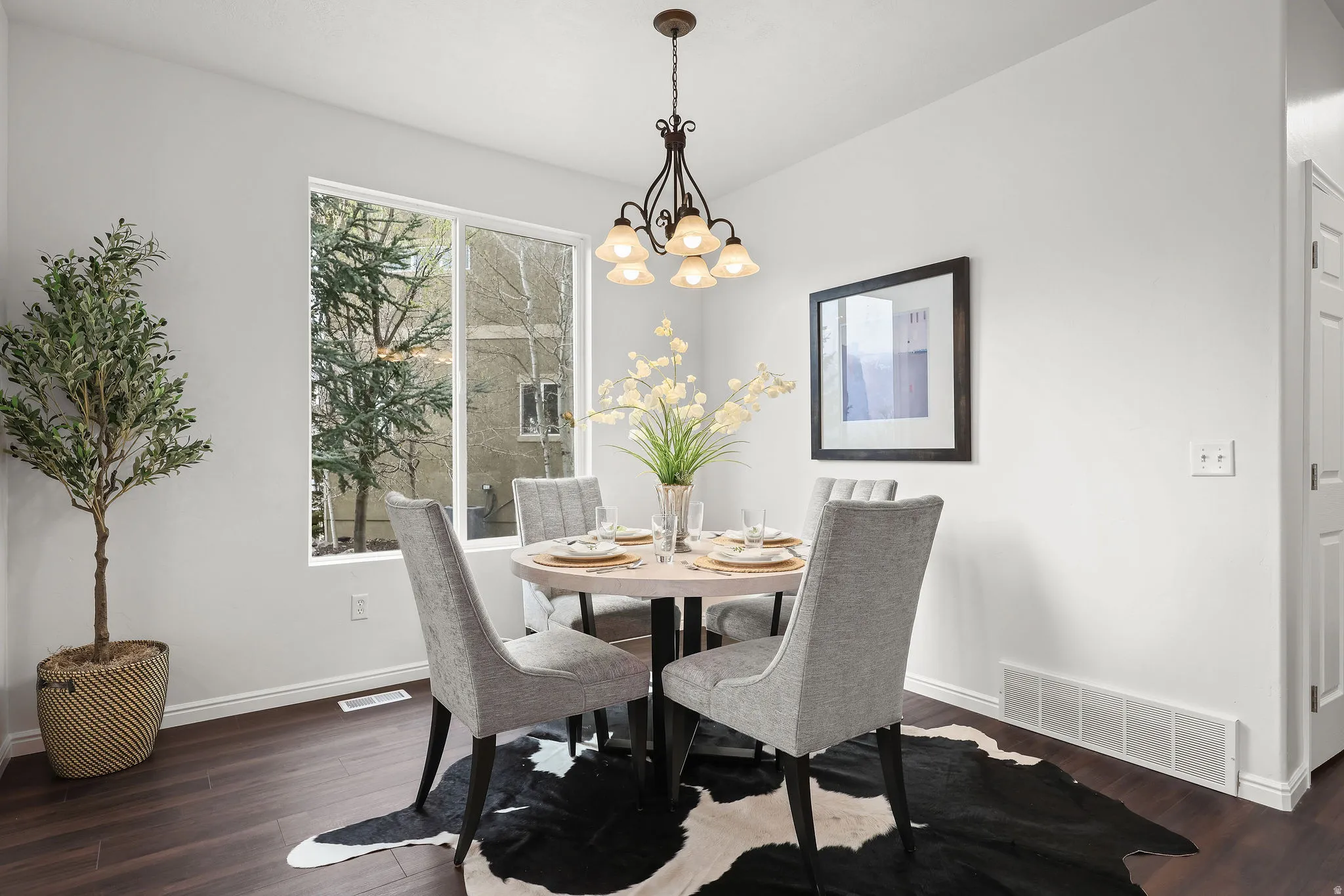 Dining space with dark wood-style flooring and hanging lights