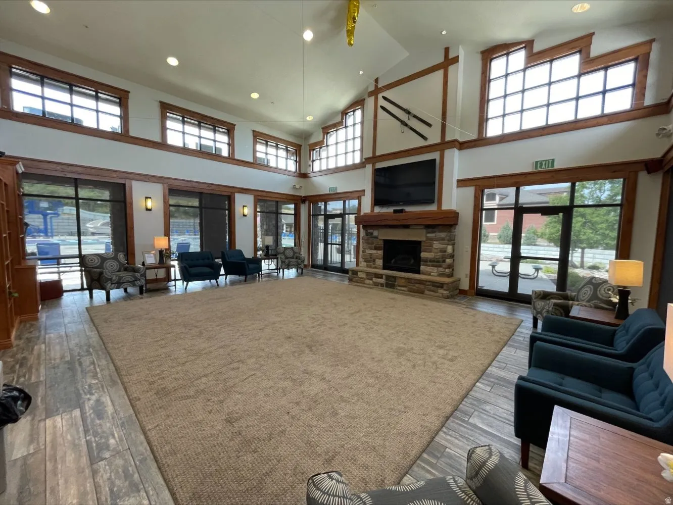 Living area featuring light wood-style flooring, recessed lighting, a stone fireplace, and lofted ceiling