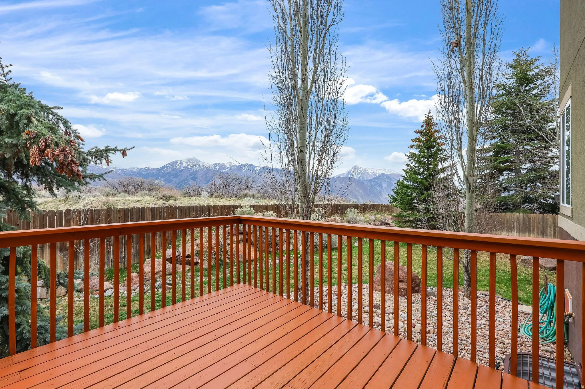 Wooden terrace featuring a fenced backyard and a mountain view