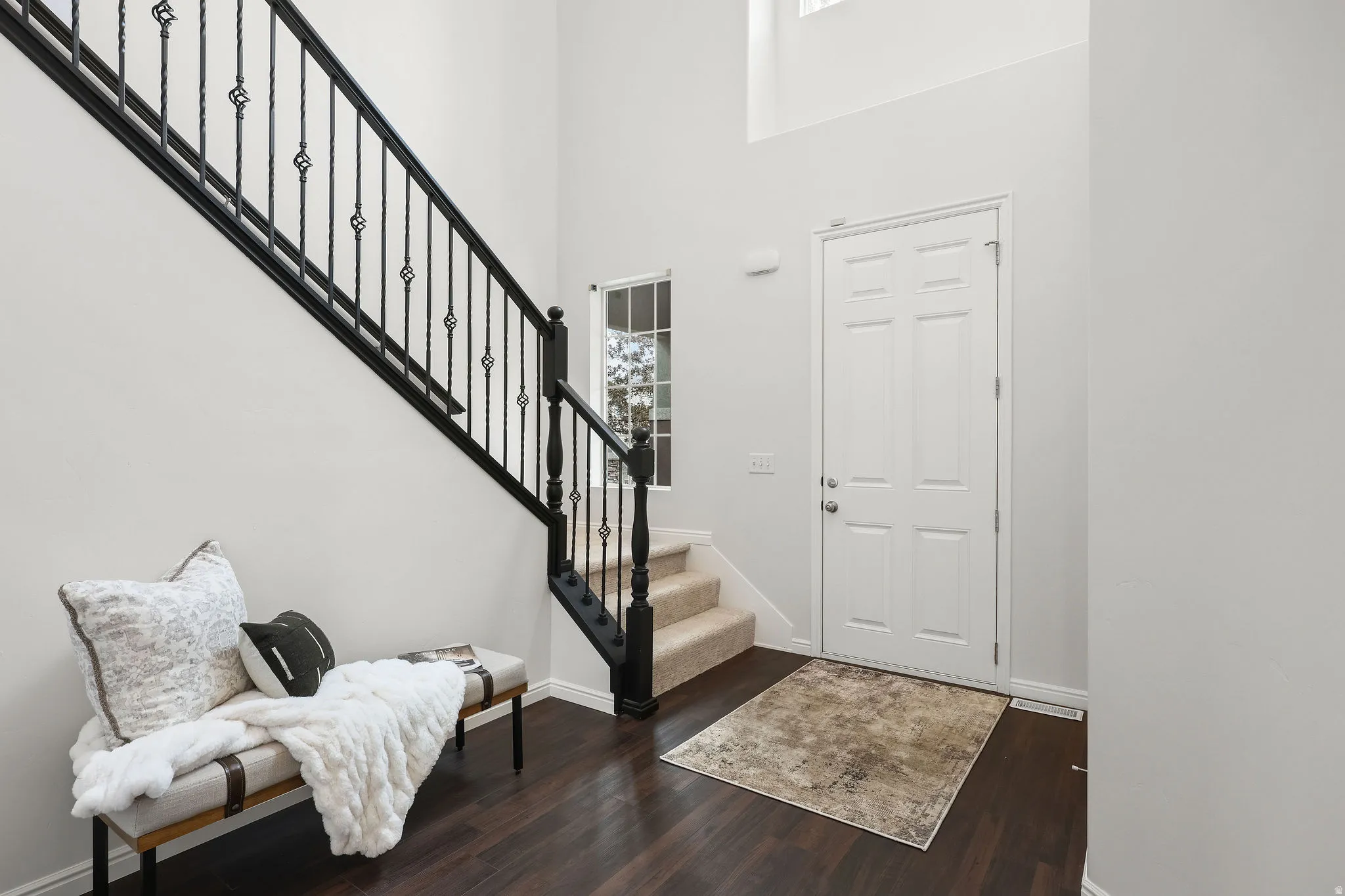 Foyer featuring a high ceiling and dark wood-style flooring