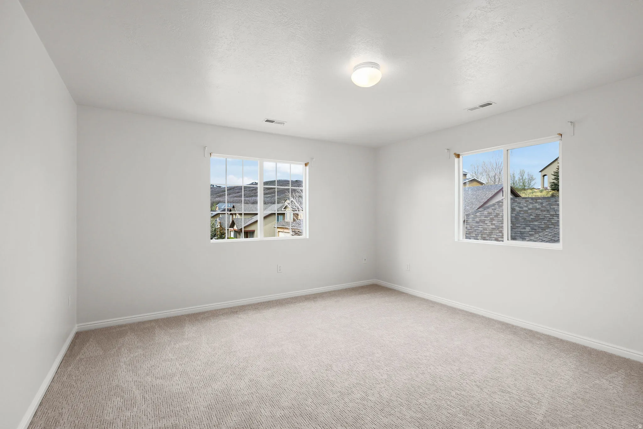 Empty room with light carpet and baseboards