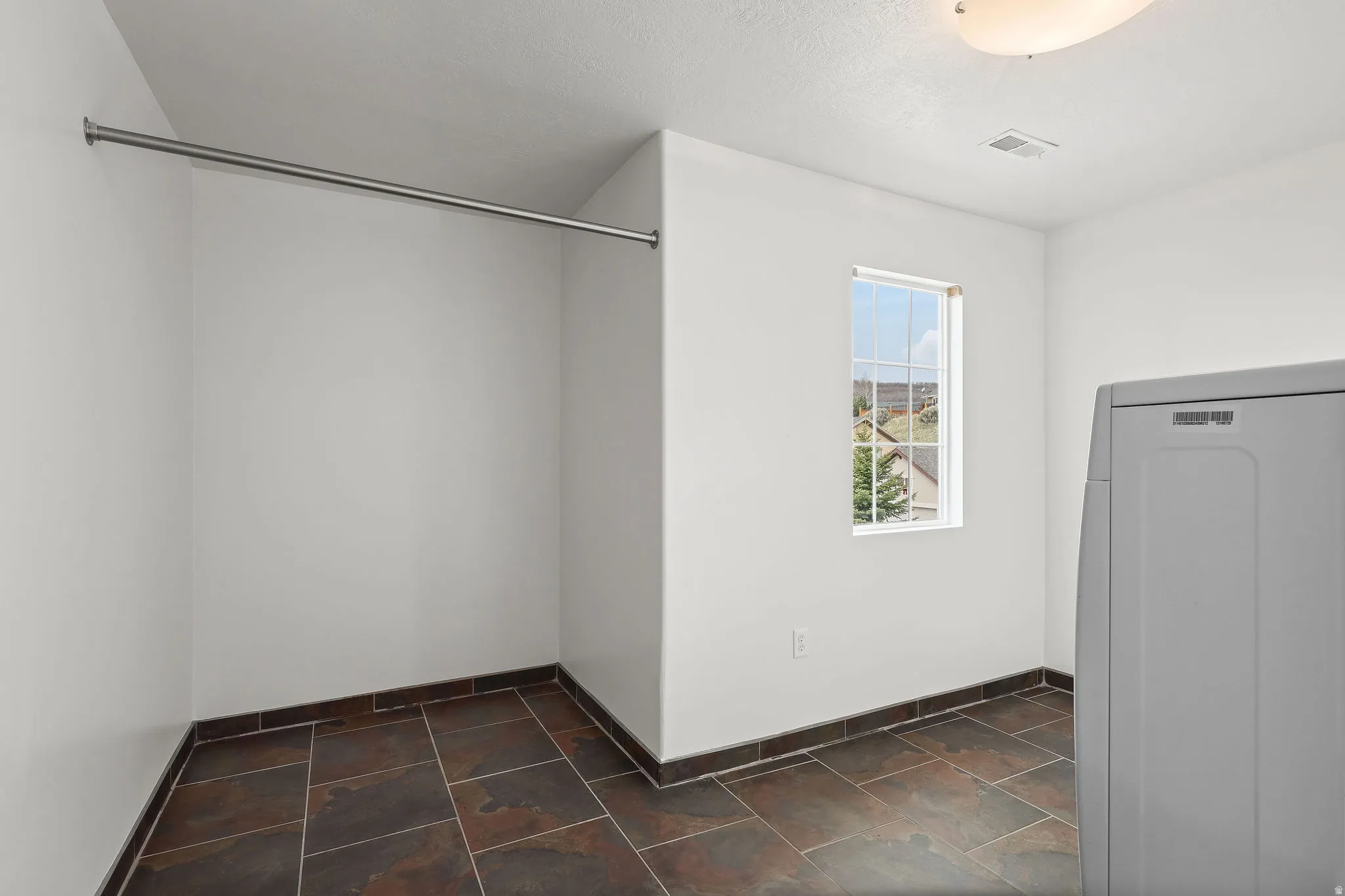 Laundry room with washer / dryer and dark stone finish floors