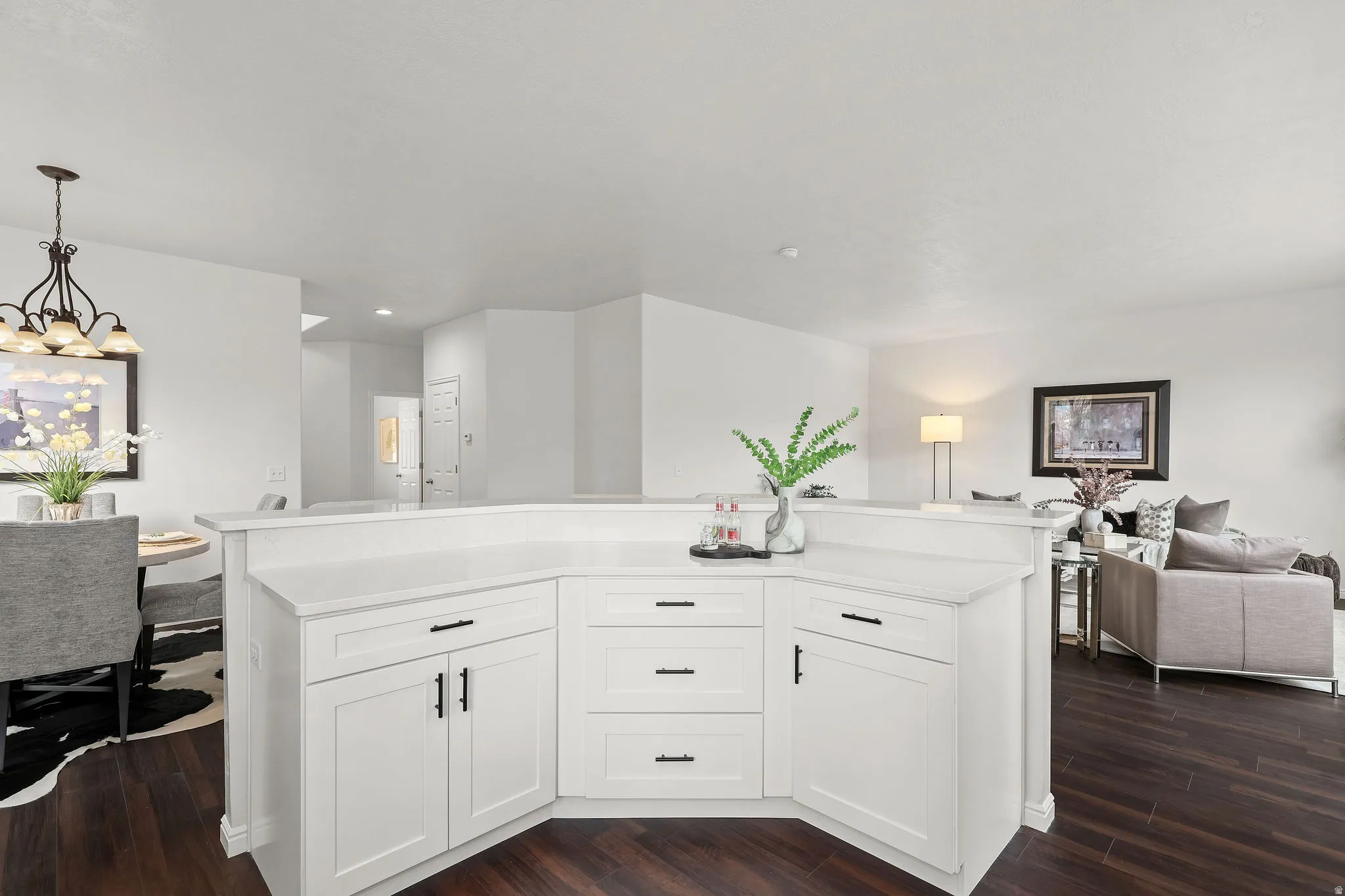 Kitchen with open floor plan, white cabinets, and dark wood-type flooring