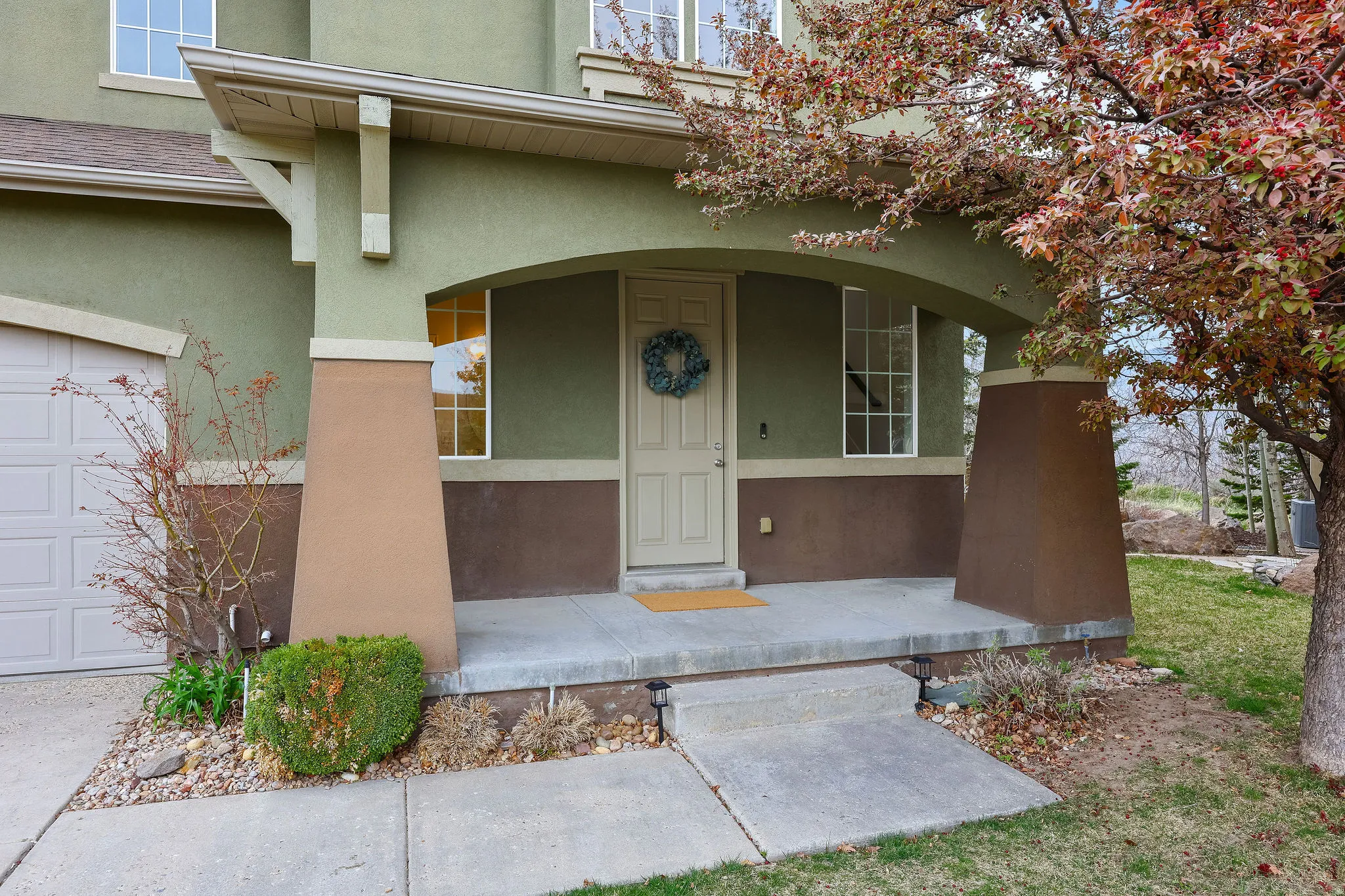 Entrance to property with covered porch and stucco siding