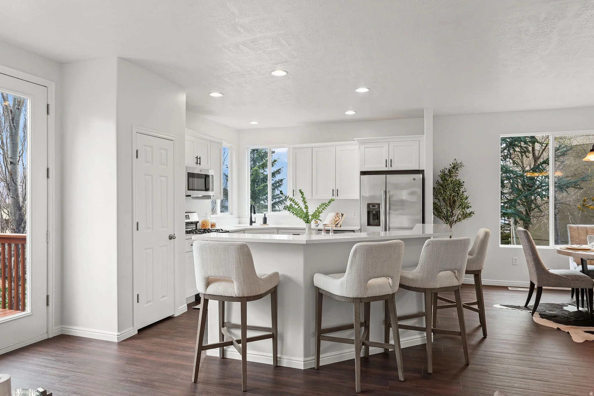 Kitchen featuring a kitchen breakfast bar, white cabinetry, a kitchen island, stainless steel appliances, and recessed lighting
