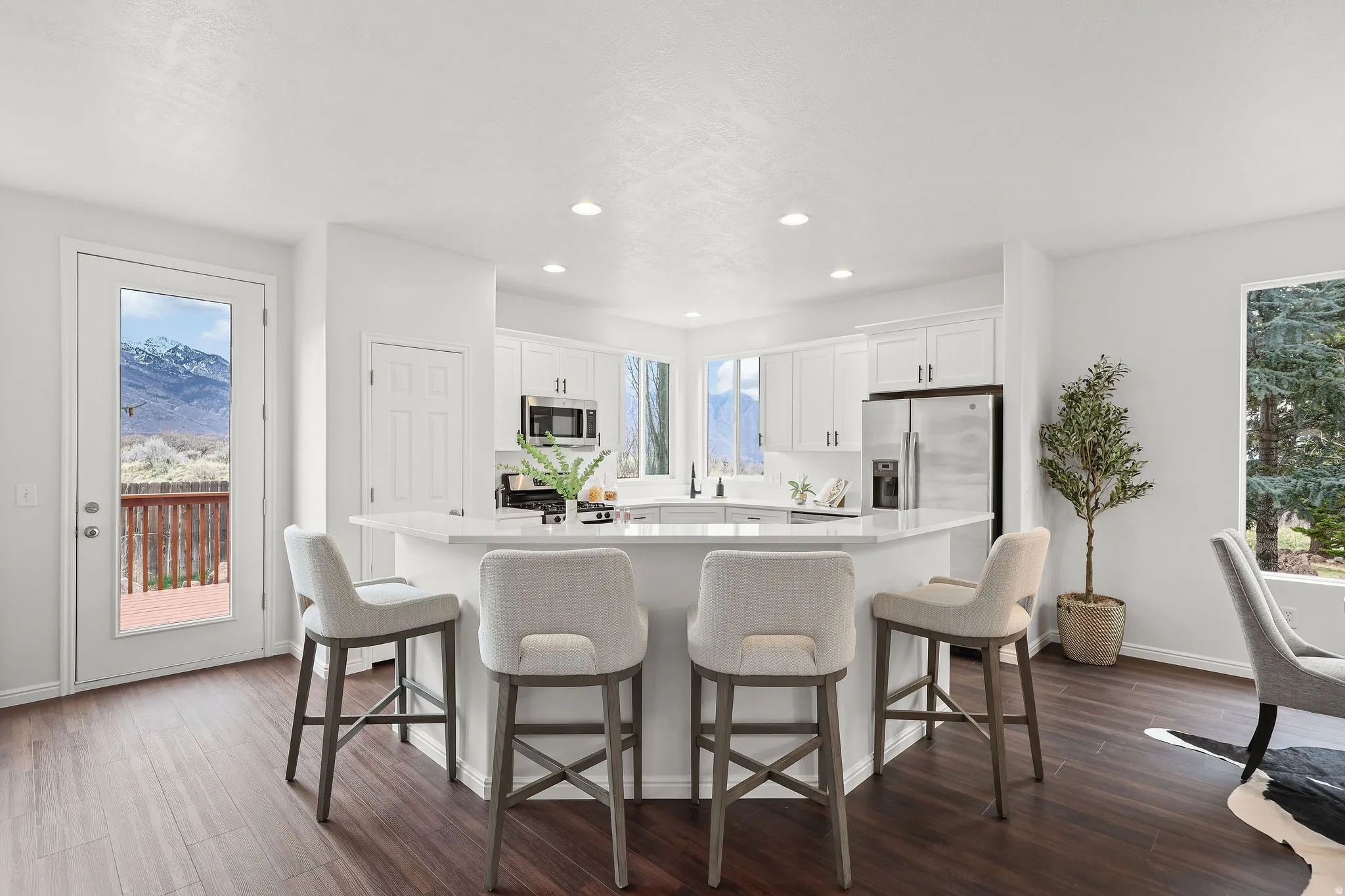 Kitchen with a breakfast bar, white cabinetry, a center island, dark wood-style floors, and recessed lighting
