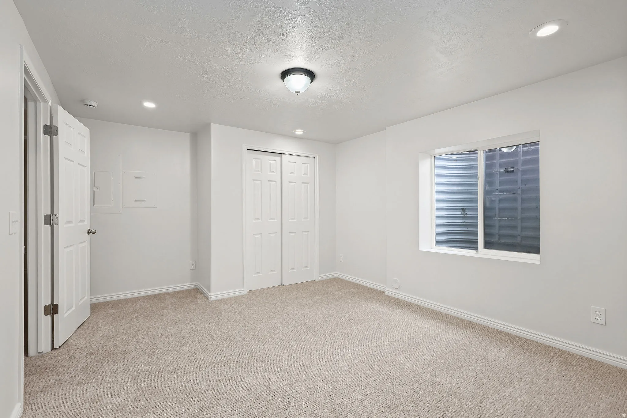 Unfurnished bedroom featuring a closet, light colored carpet, and recessed lighting