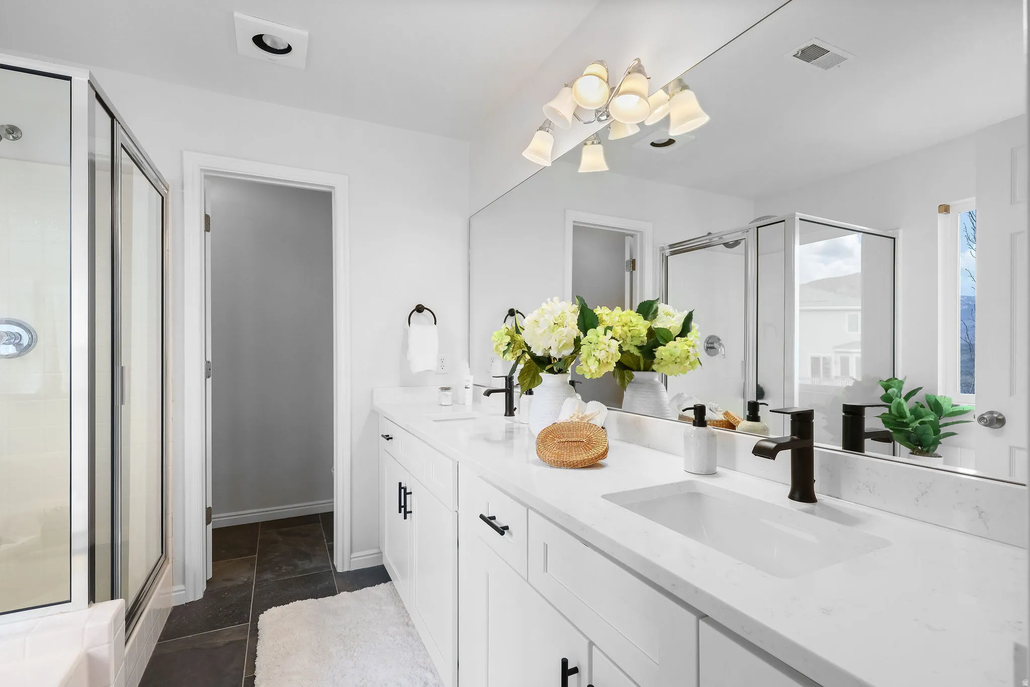 Full bath with a shower stall and double vanity