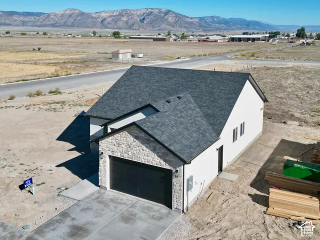 Single-story residence featuring a dark asphalt shingle roof and a concrete driveway
