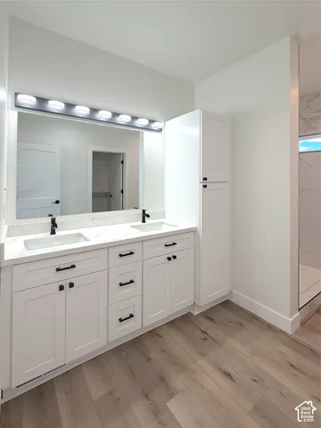 Dual vanity with under-mount sinks, white cabinetry, quartz countertop, and matte black fixtures
