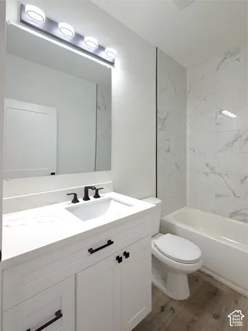 White vanity with black hardware, white rectangular sink, and black three-piece faucet