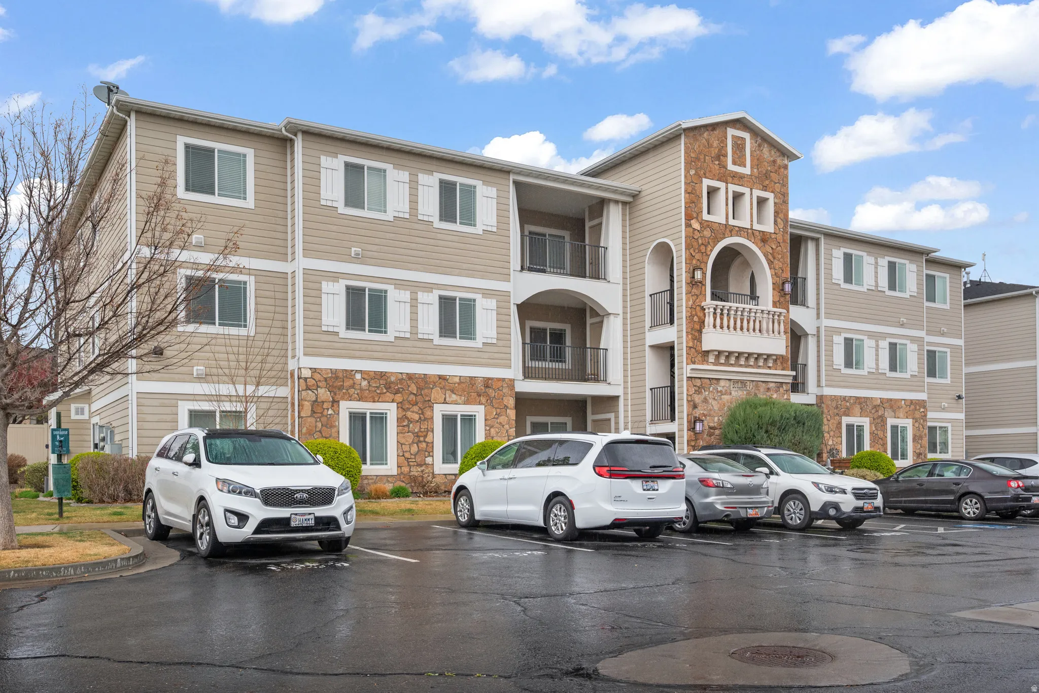 View of apartment building / complex featuring uncovered parking