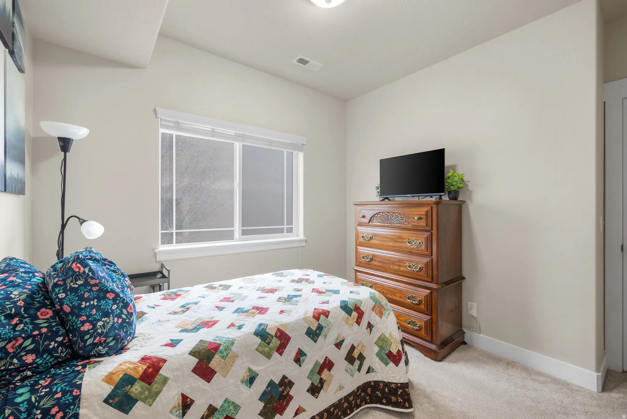 Bedroom featuring light carpet and baseboards