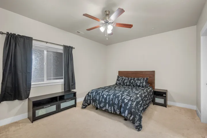 Bedroom featuring light carpet and ceiling fan