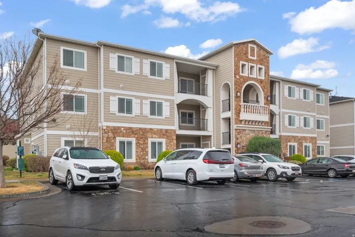 View of apartment building / complex featuring uncovered parking