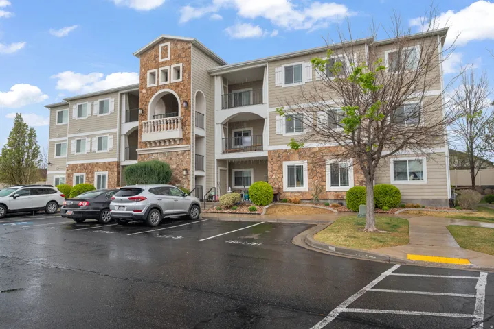 View of apartment building / complex featuring uncovered parking