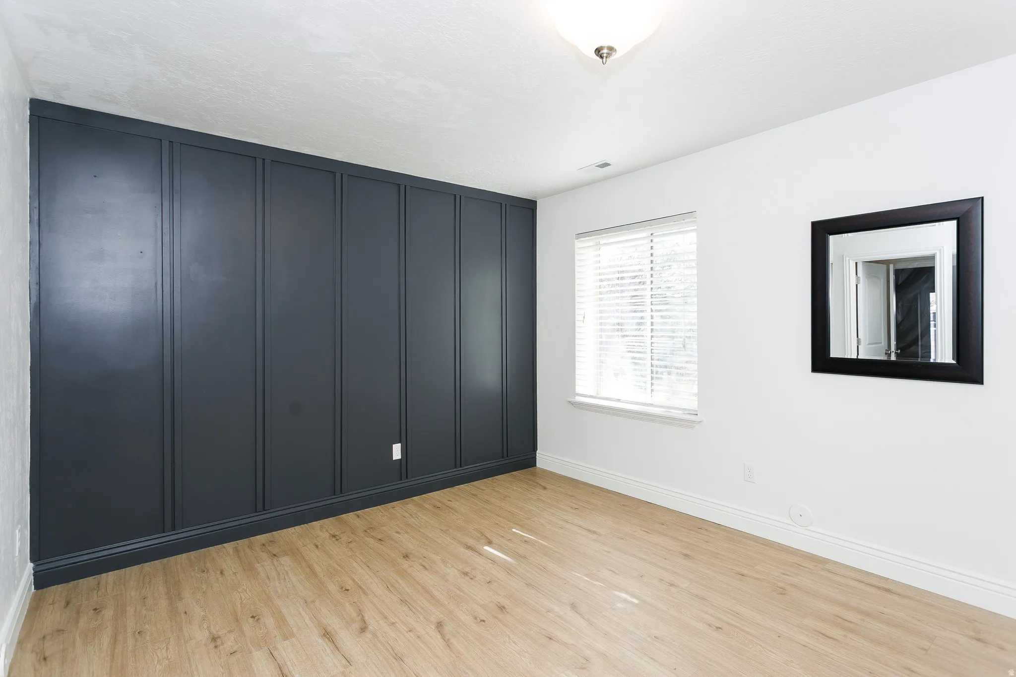 Spare room with light wood-type flooring and baseboards