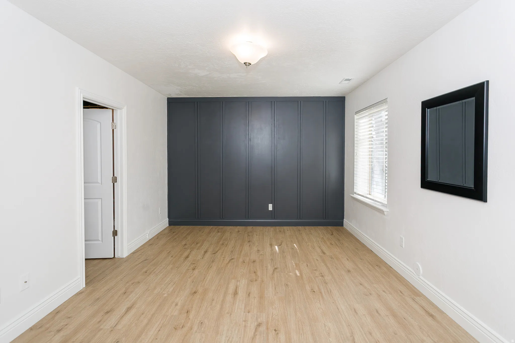 Empty room featuring light wood-type flooring and baseboards