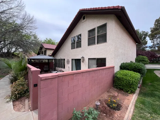 Rear view of house featuring stucco siding and a gazebo