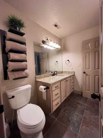 Half bath with vanity and a textured ceiling