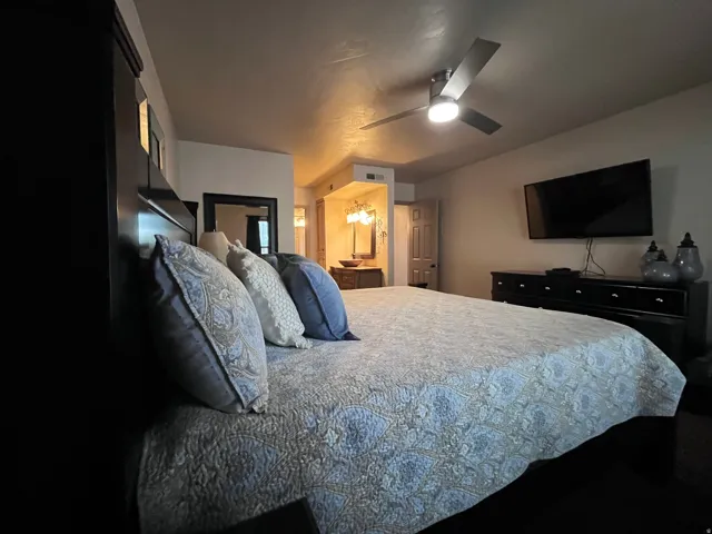 Bedroom featuring ensuite bath and a ceiling fan