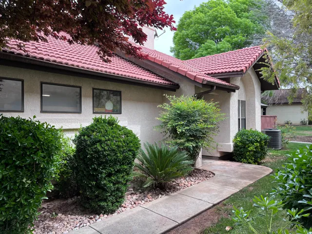 View of side of home featuring stucco siding and a tile roof