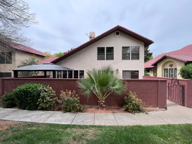 View of front of property featuring stucco siding and a gate
