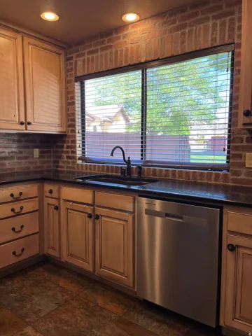 Kitchen featuring dishwasher, dark countertops, and recessed lighting
