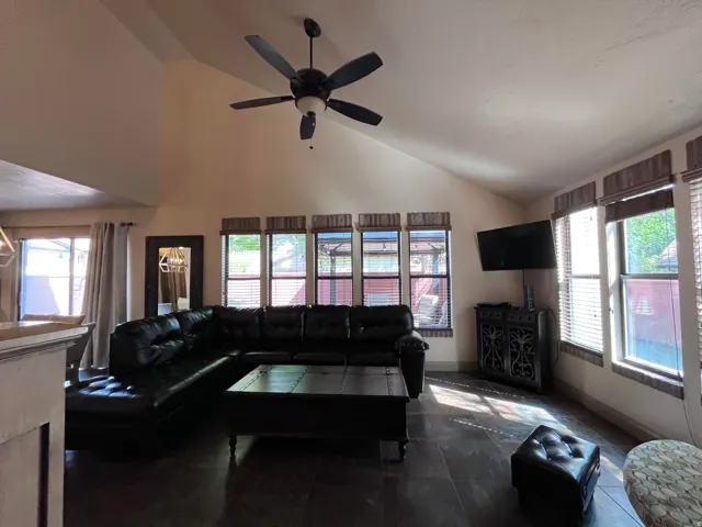 Living area with lofted ceiling and a ceiling fan