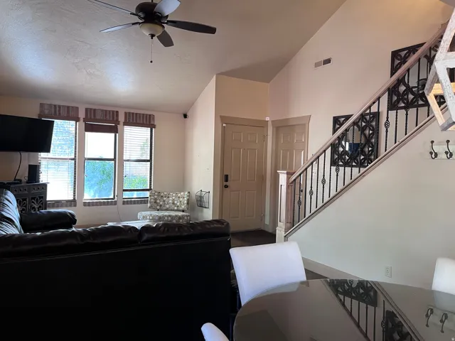 Living area with a ceiling fan and lofted ceiling