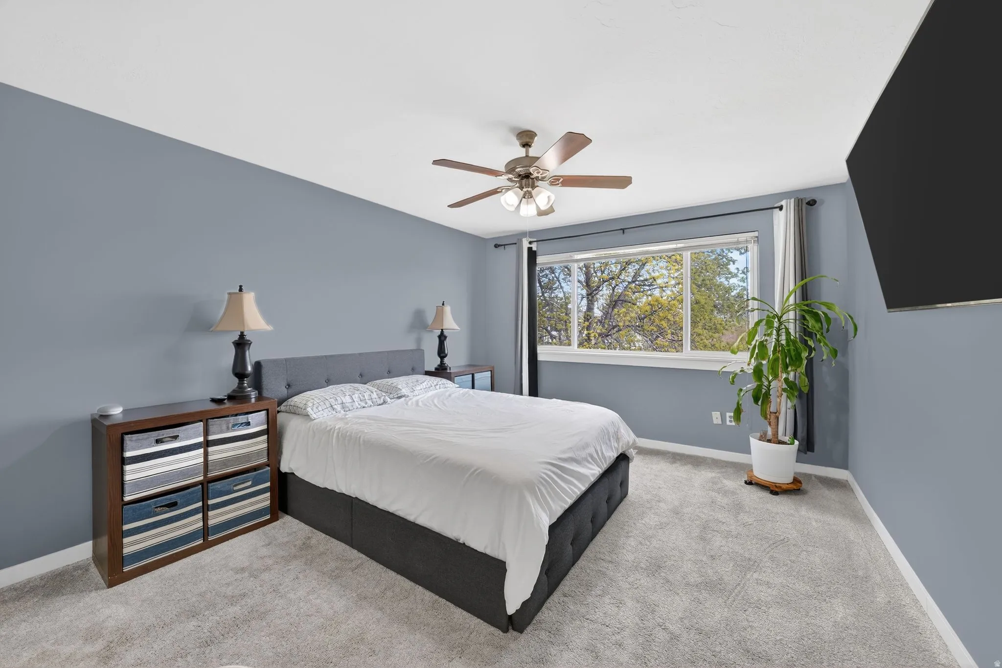 Carpeted bedroom featuring baseboards and ceiling fan